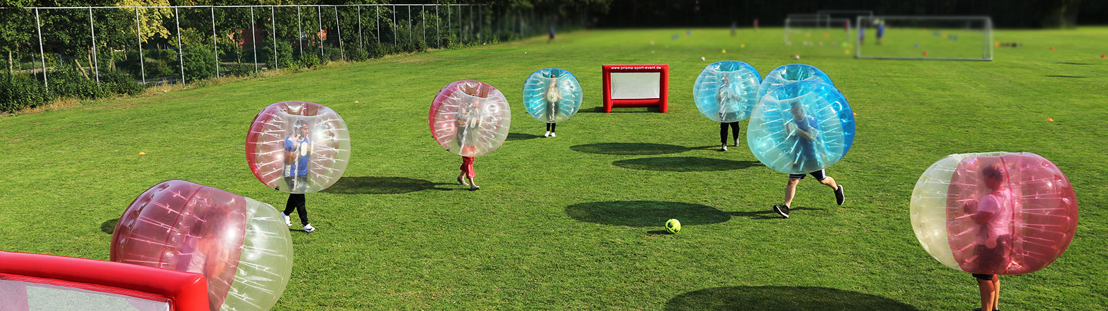 Erwachsene Teams beim gemeinsamen Bubble Soccer spielen